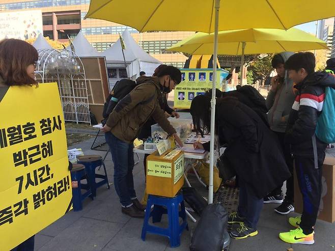 15일 낮 서울 광화문광장에서 시민들이 세월호 진상규명 서명에 참여하고 있다. 박수지 기자