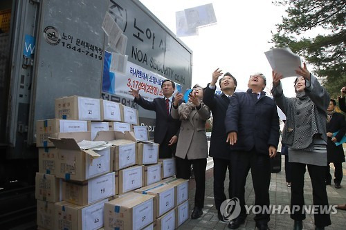 더불어민주당 우상호 원내대표와 의원들이 지난달 22일 오후 국회에서 열린 일본계 대부첩체 소멸시효 완성채권 소각행사에서 이날 파쇄할 대출 서류들을 하늘에 던지며 축하하고 있다. 이날 소각된 대출 채권은 이자 포함 3천174억원으로 2만명이 대출한 내역이다. [연합뉴스 자료사진]