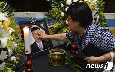 지난 6월 18일 오후 서울 은평구 서북병원에서 열린 고 김관홍 잠수사 추모제에서 한 참석자가 헌화를 하며 영정을 쓸어만지고 있다. © News1 신웅수 기자