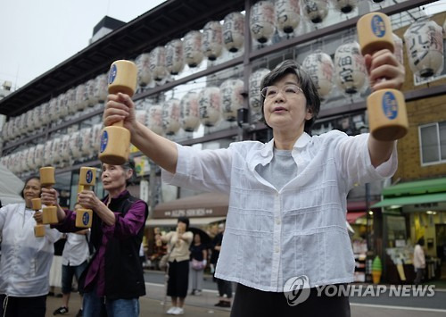 (도쿄 AFP=연합뉴스) 경로의 날인 지난 9월 19일 일본 도쿄에서 노인들이 나무 덤벨을 들고 체조를 하고 있다.