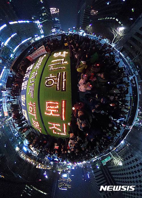 【서울=뉴시스】조수정 기자 = 2016년을 보내는 31일 밤 서울 광화문 네거리에서 열린 박근혜 대통령 퇴진 촉구 제10차 주말 촛불집회에 참가한 시민들이 촛불로 '박근혜 퇴진' 글씨를 완성하고 있다. VR카메라로 360도 촬영. 2017.01.01. chocrystal@newsis.com