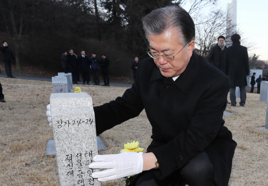 헌화 : 문재인 전 더불어민주당 대표가 11일 오전 충남 천안시 망향의 동산을 찾아 위안부 피해자 묘소에 헌화한 뒤 묘비를 살펴보고 있다. 연합뉴스