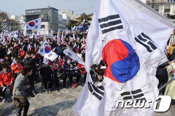26일 오후 충북 청주시 상당공원에서 박근혜 대통령 탄핵 기각을 촉구하는 태극기 집회서 20대로 추정되는 남성이 태극기를 태웠다. 경찰은 이 남성을 붙잡아 조사를 벌이고 있다. 2017.2.26/뉴스1 © News1 김용빈 기자