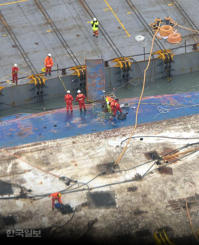 [세21] [저작권 한국일보] 모습을 드러낸 세월호를 배에 묶는 고박 작업을 하고 있다.