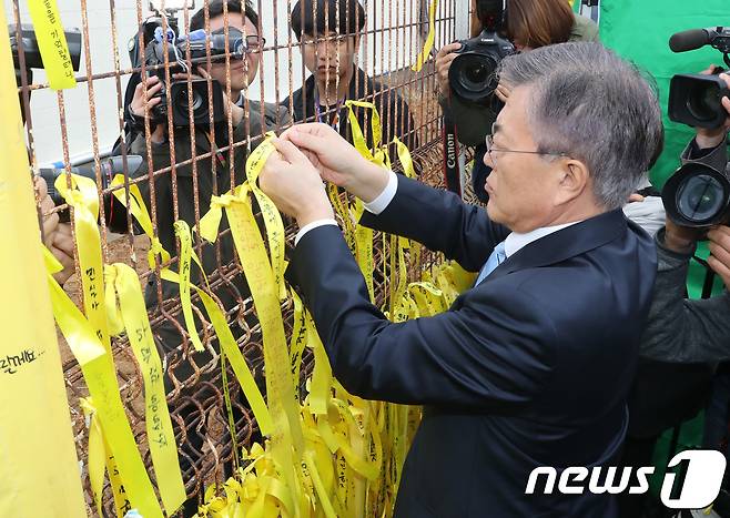 문재인 더불어 민주당 대선 후보가 6일 오후 세월호가 정박돼 있는 목포 신항을 방문해 추모 문구를 적힌 노란 리본을 달고 있다. 전민규 기자 / 20170406 © News1 안은나 기자