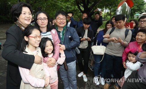 (서울=연합뉴스) 김주형 기자 = 문재인 대통령의 부인 김정숙 여사(왼쪽)가 13일 오후 서울 서대문구 홍은동 사저에서 청와대로 떠나기 전 입구에서 기다리던 시민들과 인사를 나누고 있다. 2017.5.13  kjhpress@yna.co.kr