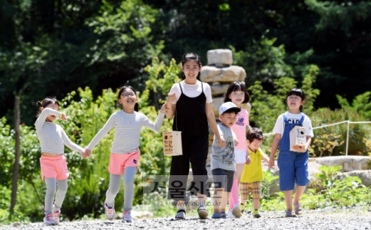 강원 철원군 동송읍에서 온 어린이들이 산새 학교에서 직접 만들고 각자 이름을 쓴 둥지를 들고 지장산 골짜기 적당한 장소에 설치하기 위해 숲길로 들어가고 있다.