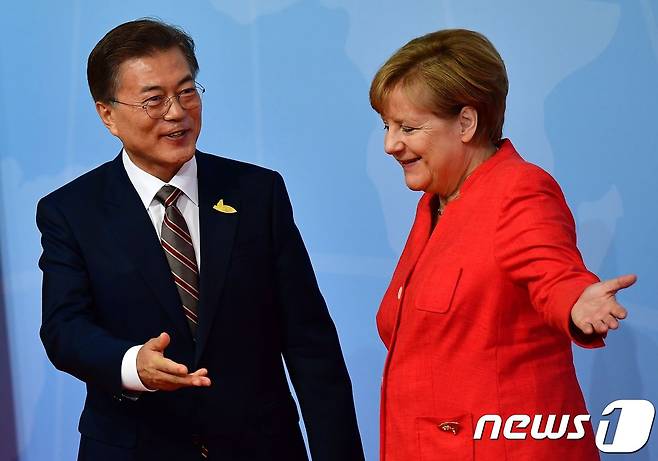 앙겔라 메르켈 독일 총리(오른쪽)가 7일(현지시간) 함부르크 주요 20개국(G20) 정상회담 행사장에 도착한 문재인 대통령에게 자리를 안내하고 있다. © AFP=뉴스1 © News1 최종일 기자
