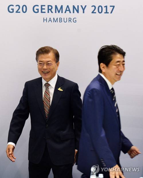 자리 향하는 한일 정상  (함부르크=연합뉴스) 배재만 기자 = 문재인 대통령과 아베신조 일본 총리가 7일 오전(현지시간) 독일 함부르크 G20 정상회의장 메세홀 양자회담장에서 열린 한일 정상회담에서 악수를 한 뒤 각자 자리로 향하고 있다. 2017.7.7 scoop@yna.co.kr