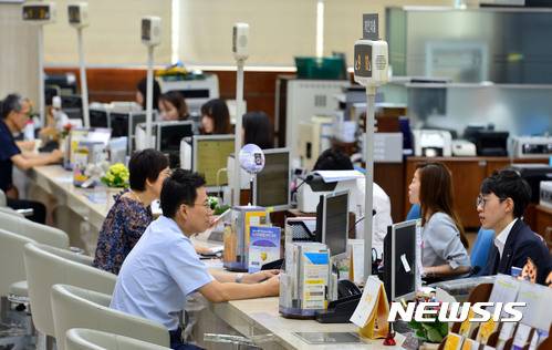 【서울=뉴시스】박진희 기자 = 정부가 서울 전역을 투기과열지구로 묶고, 대출 규제를 강화한 8·2 부동산대책 시행을 앞둔 3일 오후 서울 영등포구 한 은행 창구 직원들이 고객들과 상담을 하고 있다. 정부는 지난 2일 서울시 전역과 경기 과천, 세종시 등 투기과열지구의 주택담보인정비율(LTV)과 총부채상환비율(DTI)의 한도를 40%로 강화하고, 이중 강남 4구 등 투기지구로 묶인 11곳에 대해서는 주택담보대출을 가구당 1건으로 제한키로 했다.강력한 대출 규제책에 놀란 대출 수요자들은 대출 시기를 앞당겨야 하는지, 대출 한도는 얼마나 줄어드는지를 걱정하며 상황을 예의주시하는 모습을 보이고 있다. 2017.08.03. pak7130@newsis.com