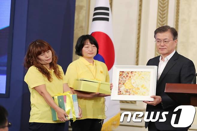 문재인 대통령이 16일 오후 청와대 영빈관에서 4.16 세월호 참사 피해자 가족을 대표해 박혜영, 정부자 씨로부터 '416 단원고 약전-짧은 그리고 영원한-'과 액자, 보석함 등을 선물 받고 있다. (청와대) 2017.8.16/뉴스1 © News1 이광호 기자