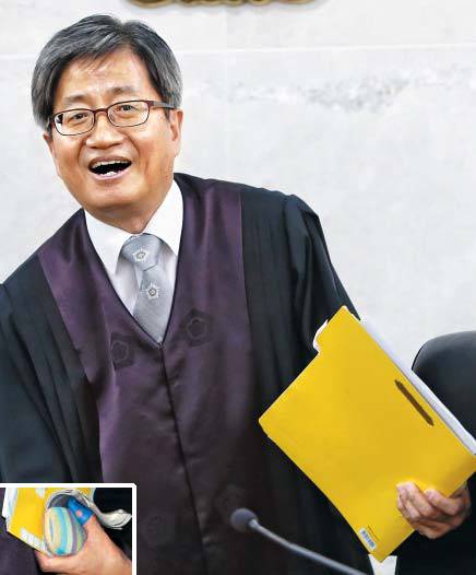 엄지손가락에 골무 낀 김명수 후보자 - 21일 대법원장 후보자로 지명된 김명수 춘천지법원장이 춘천지법에서 재판을 마치고 밝은 표정으로 일어서고 있다. 김 후보자는 법원장이지만 재판도 해왔다. 서류철을 든 김 후보자의 왼손 엄지손가락에 골무가 끼워져 있다(왼쪽 작은 사진). 재판 기록을 넘기기 쉽도록 골무를 끼는 판사가 많다. /연합뉴스