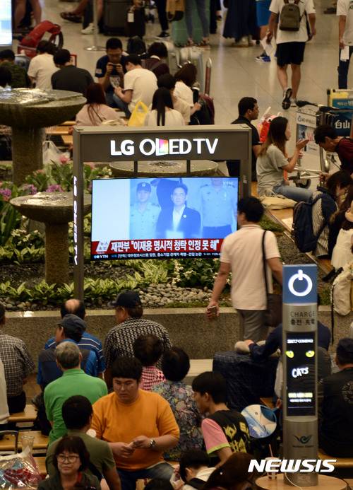 【인천공항=뉴시스】홍찬선 기자 = 박근혜(65) 전 대통령과 최순실(61)씨에게 뇌물을 제공한 혐의로 기소된 이재용(49) 삼성전자 부회장의 1심 선고가 열린 25일 오후 인천공항에서 이용객들이 실시간 뉴스속보를 지켜보고 있다. 2017.08.25.  mania@newsis.com
