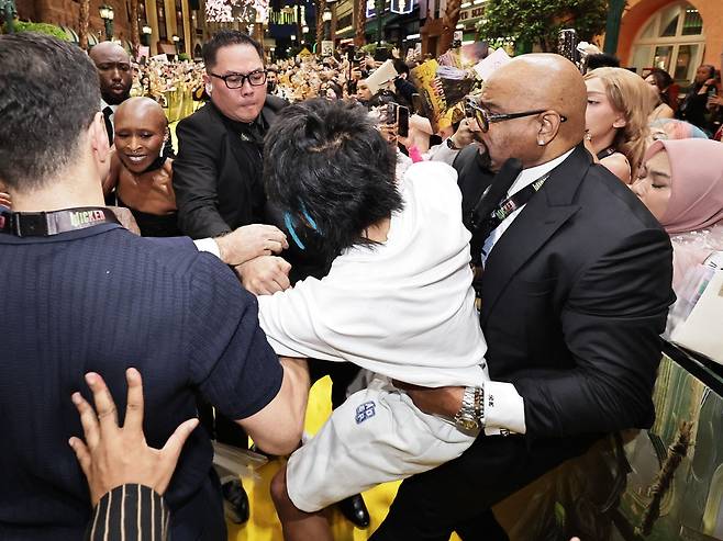 팝스타 아리아나 그란데를 레드카펫 위에서 덮친 호주 출신 남성 존슨 웬이 경호원들에게 붙잡혀 끌려 나가는 모습. /AFP 연합뉴스