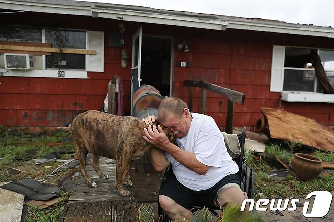 폭풍우 속에 잃어버린 애완견을 찾은 락포트 주민이 재회의 울음을 터뜨리고 있다. © AFP=뉴스1