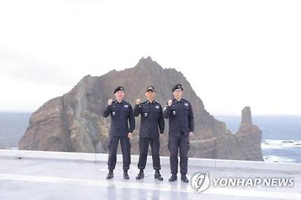 オムサングも独島警備(経費)大将(の中)と隊員たちが拳をむっと握って見せて領土守護意志を押し堅めている. [独島警備隊提供]