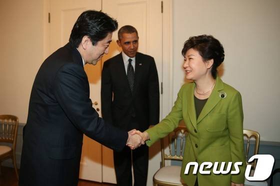 작년 3월25일 네덜란드 헤이그 소재 미국 대사관저에서 열린 한미일 정상회담에 참석한 박근혜 대통령(오른쪽)과 아베 신조 일본 총리가 악수를 나누고 있다.(청와대) 2014.3.26/뉴스1