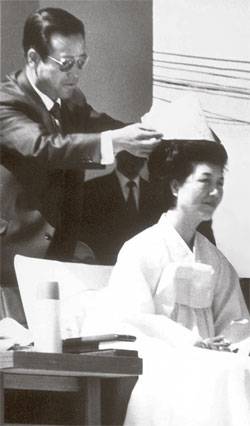 1971년 4월 15일 7대 대통령 선거 유세를 벌인 춘천 공설운동장에서 김종필 공화당 부총재가 고깔모자를 육영수 여사에게 씌워주고 있다.