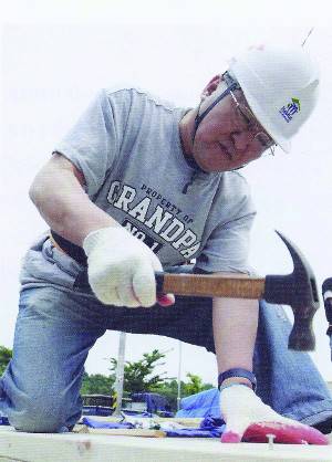 해비타트운동에 참여해 집짓기 망치질을 하는 모습.