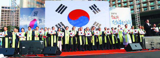 한국교회 주요 지도자들이 9일 서울광장에서 열린 '광복 70년 한국교회평화통일기도회'에서 행사 순서지에 새겨진 태극기를 펼쳐 들고 '우리의 소원은 통일' 노래를 함께 부르고 있다. 이날 기도회는 애국가 제창으로 시작해 통일 노래 합창으로 막을 내렸다. 강민석 선임기자