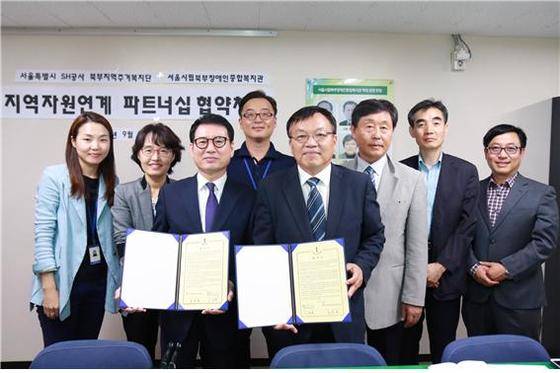 이청용 서울시 SH공사 북부지역주거복지단 단장(오른쪽)과 손영호 서울시립북부장애인종합복지관 관장(왼쪽) 이 22일 상호협력 MOU를 체결한 뒤 기념사진을 촬영하고 있다.  /사진제공=SH공사 © News1