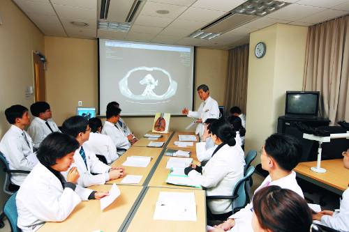 삼성서울병원 폐암센터 협진 광경. 혈액종양내과 박근칠 교수(스크린 오른쪽)가 서서 다른 의사들에게 환자의 상태에 대해 설명하며 의견을 구하고 있다. 삼성의료원 제공