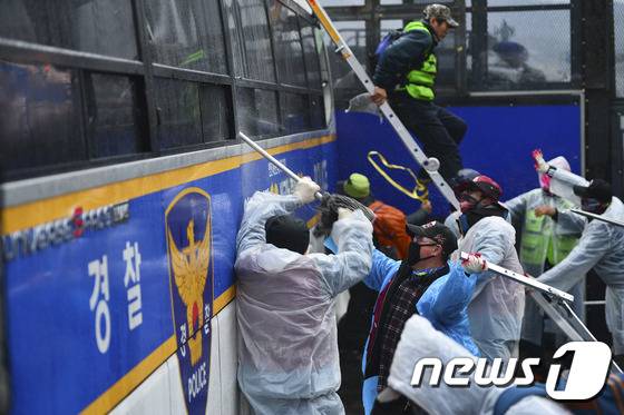 14일 오후 서울 광화문네거리에서 민중총궐기 투쟁대회를 마친 민주노총 조합원들이 경찰 차벽을 넘기 위해 경찰과 충돌하고 있다. /뉴스1 © News1 신웅수 기자