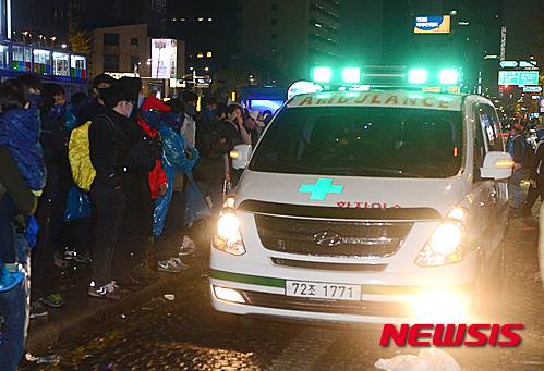 【서울=뉴시스】14일 저녁 서울 광화문에서 열린 민중총궐기대회에서 한 농민이 차벽에 밧줄을 걸고 당기던 중 경찰의 물대포를 직사로 맞고 쓰러져 뇌진탕 증세를 보였고, 아스팔트에 누워있다가 구급차로 호송되고 있다. 2015.11.14.  suncho21@newsis.com