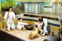 우리나라의 화장실 문화를 엿볼 수 있도록 만들어진 인형들. 대변을 본 아이 옆에 강아지가 다가가고 있다.