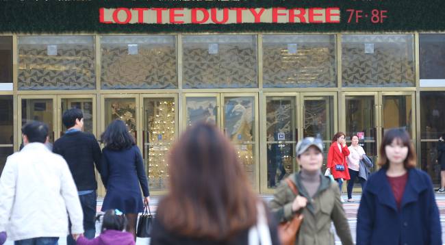 People walk past the Lotte Duty Free store at Lotte World Tower in Gangnam, Seoul. (Yonhap)