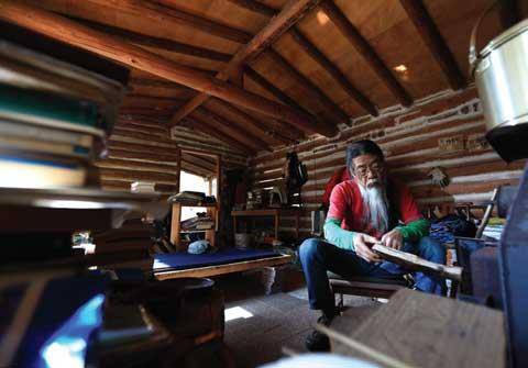 [월간산]화목난로에 장작을 넣는 민경국씨. 늦여름부터 산의 장작을 모아 겨울을 난다.