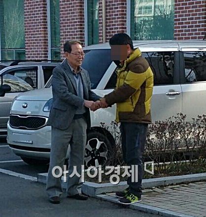 27일 오후 김만식 몽고식품 회장(왼쪽)이 운전기사 A씨를 만나 사과 후 악수를 나누는 모습.