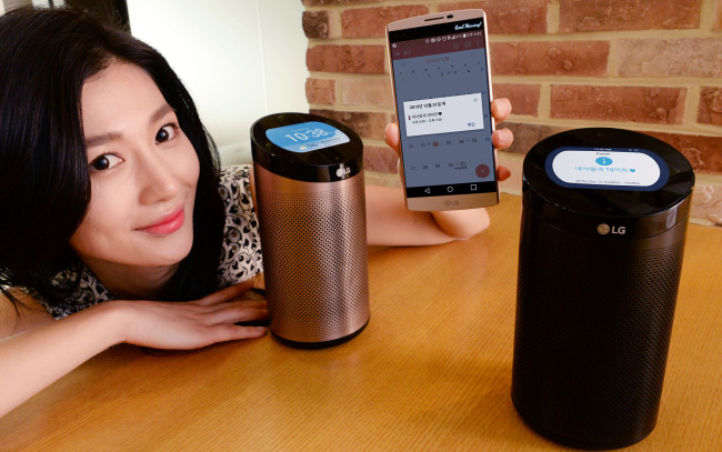 A models poses with SmartThinQ Hub, a cylinder-shaped gadget that collects the data of smart home appliances and shows them on the built-in display or users&lsquo; smartphones. (LGE)