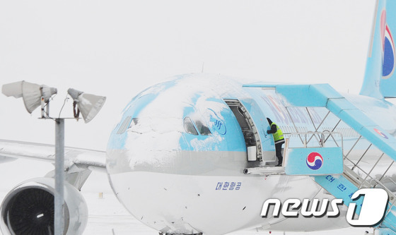 제주지역에 내린 많은 눈으로 24일 제주국제공항 활주로에 눈이 쌓여 운항을 포기한 항공기가 멈춰서 있다.2016.1.24/뉴스1 © News1 이석형 기자