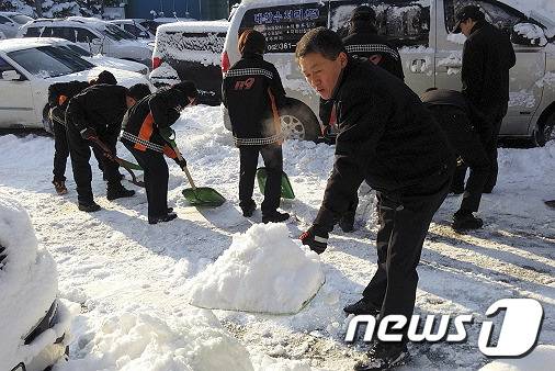 25일 광주 서부소방서 장용주서장이 광주 서구 화정동 한 도로에서 광주서부소방서 직원들과 함께 제설작업을 하고 있다.(광주서부소방서 제공)2015.1.25/뉴스1 © News1 신채린 기자