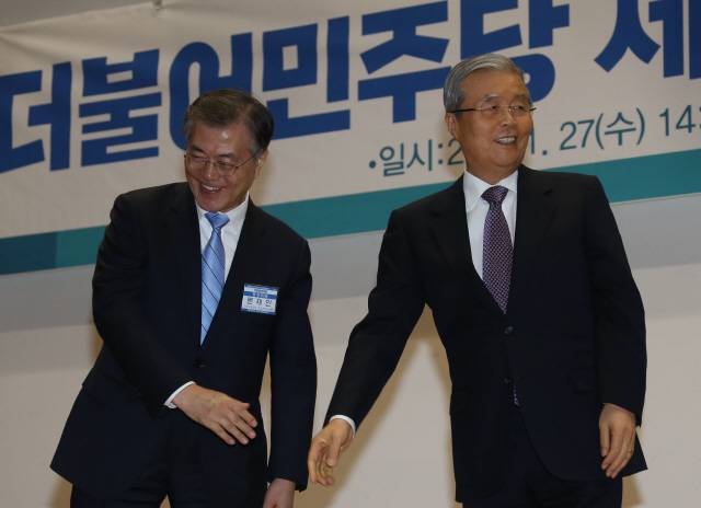 문재인 더불어민주당 대표(왼쪽)가 27일 오후 국회 의원회관에서 열린 중앙위원회의에서 김종인 비상대책위원장에게 최고위원회의 권한을 넘긴 뒤 잡았던 손을 놓고 연단을 내려가고 있다. 문 대표는 이날 대표직에서 물러났다. 이정우 선임기자 woo@hani.co.kr
