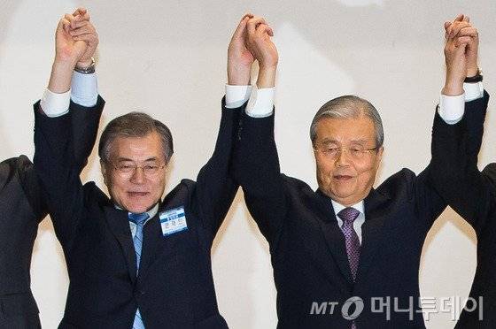 문재인 더불어민주당 대표가 27일 서울 여의도 국회 의원회관에서 열린 제4차 중앙위원회의에서 지도부 총사퇴를 선언한 뒤 김종인 비대위원장 겸 선대위원장을 비롯한 비대위원들과 손을 들어보이고 있다. 문 대표는 이 자리에서 당 대표로 선출된 후 353일만에 김종인 위원장에게 전권을 이양하고 총선정국에서 백의종군한다. 2016.1.27/뉴스1  <저작권자 © 뉴스1코리아, 무단전재 및 재배포 금지>