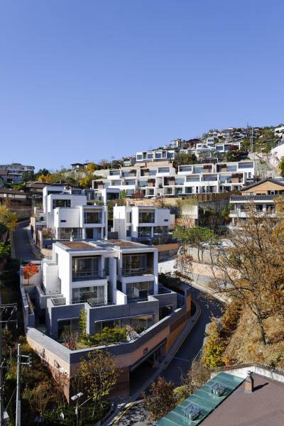 오보에힐스는 완만한 S자 형태로 단지를 가로지르는 도로를 따라 분양면적 기준 454~482㎡ 크기의 집 18가구가 자리 잡고 있는 모습이다. 건물 지붕에는 금속 재질로 윤곽선을 넣었고 2층 테라스 출입구 벽면은 나무로 처리했다. 최대한 자연을 집 안으로 끌어들이려 베란다 마루(데크)에 구멍을 내면서까지 기존 녹지의 소나무를 보존했다. /사진제공=ITM유이화건축사무소 (C)Shinichi Sato