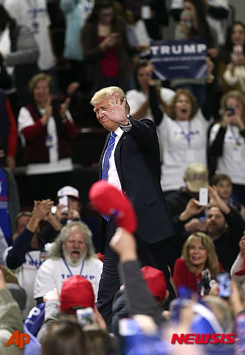 【플로렌스=AP/뉴시스】미국 공화당 대선 후보인 부동한 재벌 도널드 트럼프가 사우스캐롤라이나주(州) 플로렌스에서 한 유세에서 연단에 오르며 지지자들에게 손을 흔들고 있다.  2016.02.06