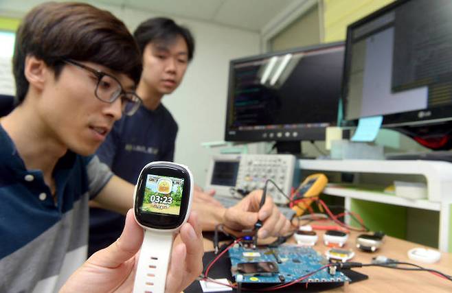 키위플러스가 IoT 플랫폼을 스마트워치 탑재에 성공하고 양산에 들어갔다. 키위플러스 직원이 ‘키위 워치’를 테스트하고 있다.<전자신문 DB>