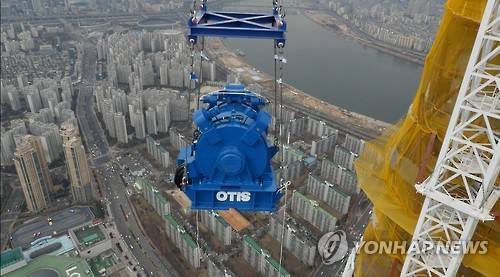 123층 1분에 오른다…롯데타워 전망대 엘리베이터 착공     (서울=연합뉴스) 롯데월드타워 123층을 수직이동할 수 있는 전망대용 엘리베이터의 마지막 작업인 권상기 설치가 22일 시작됐다. 이 엘리베이터는 지하 2층부터 전망대 121층까지 총 496ｍ 구간을 운행하는 더블데크 엘리베이터 승강기로, 세계에서 가장 긴 구간이다. 2016.2.22 << 오티스 엘리베이터 코리아 제공 >>     photo@yna.co.kr