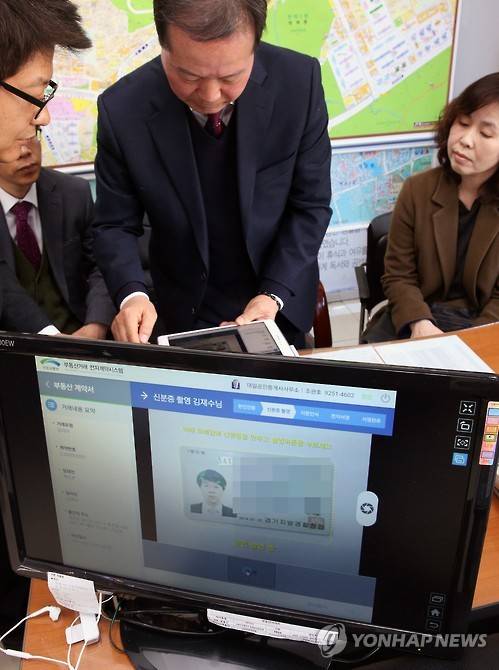 국내 첫 부동산 전자계약     (서울=연합뉴스) 전수영 기자 = 부동산 거래도 이제 전자계약으로 한다. 24일 오후  서울시 서초구의 한 공인중개사무소에서 백모씨와 김모씨(오른쪽)가 종이계약서 없이 전자계약으로 전세계약을 진행하고 있다. 사진 가운데는 공인중개사. 국토부는 전자계약시스템을 포함해 4년간 154억원을 투입하는 '부동산거래 통합지원시스템 구축사업'을 작년 시작했으며 전자계약시스템은 이미 구축을 완료했다고 밝혔다. 전자계약에 필요한 스마트폰 전자서명 애플리케이션 개발이 상반기 완료되면 서초구를 대상으로 시범사업이 시행될 예정이다.          swimer@yna.co.kr