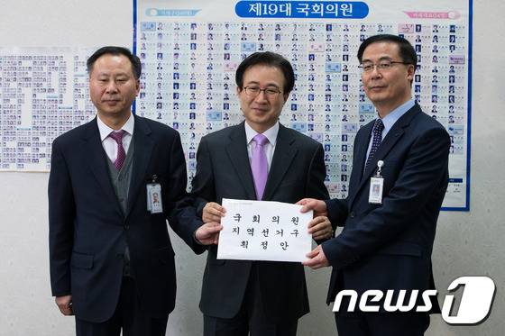 김세환 국회의원선거구획정위원회 사무국장(오른쪽)이 28일 국회에 선거구획정안을 전달하고 있다.  2016.2.28/뉴스1 © News1 유승관 기자