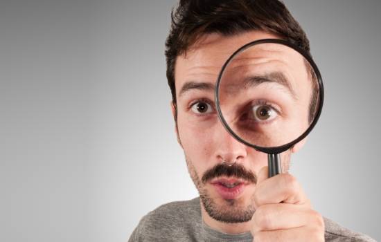 돋보기로 자세히 관찰하는 남자