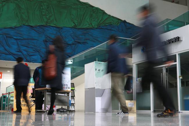 Employees head to their offices in a building in Seoul. (Yonhap)
