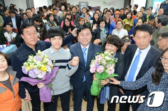 부산 부산진구갑에 출마한 김영춘 더불어민주당 후보가 13일 저녁 자신의 선거사무소에서 당선이 확실시 되자 아내와 아들 준현군과 손을 흔들고 있다. 2016.4.13/뉴스1 © News1 박기범 기자