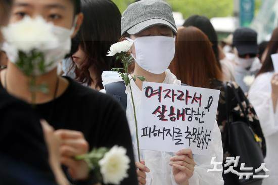 21일 오후 서울 강남역 10번 출구에서 진행된 ‘강남 묻지마 살인’ 추모집회 참가자들이 침묵행진을 하고 있다. 이날 추모집회 참가자들은 흰색 마스크를 착용하고 국화를 든 채 강남역 10번 출구를 출발해 사건 현장 앞 묵념으로 추모 분위기를 이어갔다. (사진=황진환 기자)