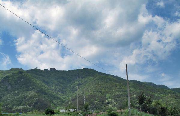 [월간산]안보광리 마을회관에서 올려다본 서대산 정상. 정상 오른쪽 두 개로 보이는 견우장연대바위. 오른쪽 885m봉(제2헬기장) 오른쪽 능선이 흥국사 방면 능선이다. 정상과 885m봉 사이는 성안이골. 계곡 입구 희끗한 건물은 효심사이다.