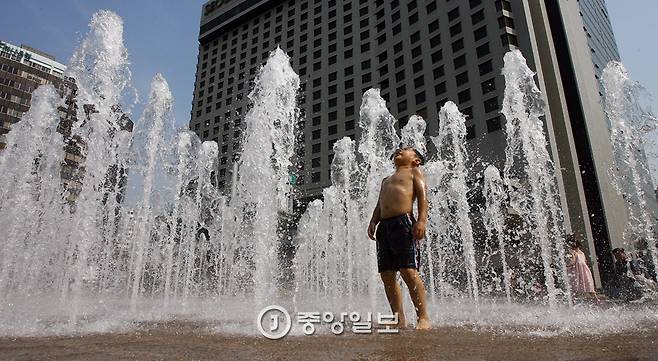 서울광장 바닥분수에 뛰어든 아이가 물을 맞으며 더위를 식히고 있다. 박종근 기자
