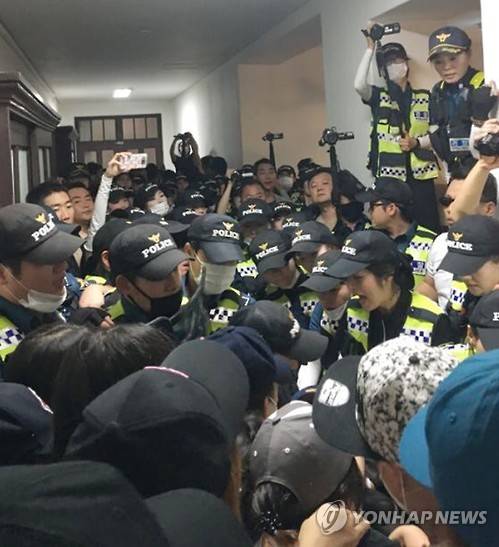 경찰과 대치 중인 학생들     (서울=연합뉴스) 직장인 대상 평생교육 단과대학을 설립 방침에 반발하면서 이화여대 본관을 사흘째 점거하던 학생들이 30일 오후 학교 측 요청을 받은 경찰들과 대치하고 있다. 2016.7.30 [독자제공=연합뉴스]     cityboy@yna.co.kr